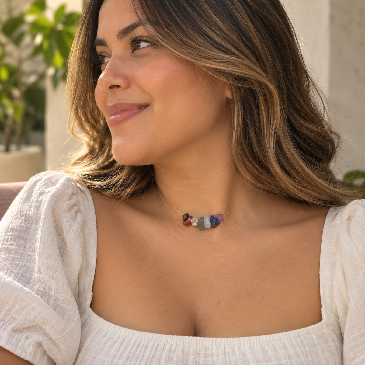 Mujer usando el Collar Equilibrio 7 Chakras con blusa blanca