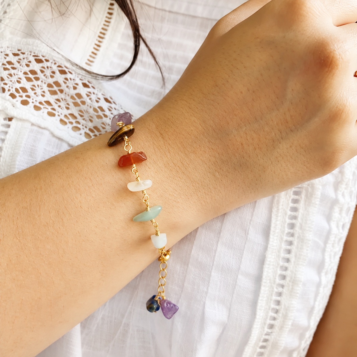Mujer con blusa blanca usando la Pulsera Conexión 7 Chakras con piedras naturales