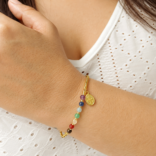 Mujer usando la Pulsera 7 Chakras con San Benito con blusa blanca