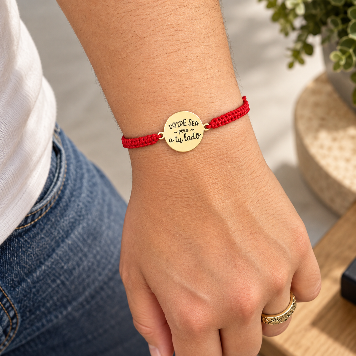 mujer usando pulsera de cordón rojo con dijes de acero inoxidable que le regaló el esposo