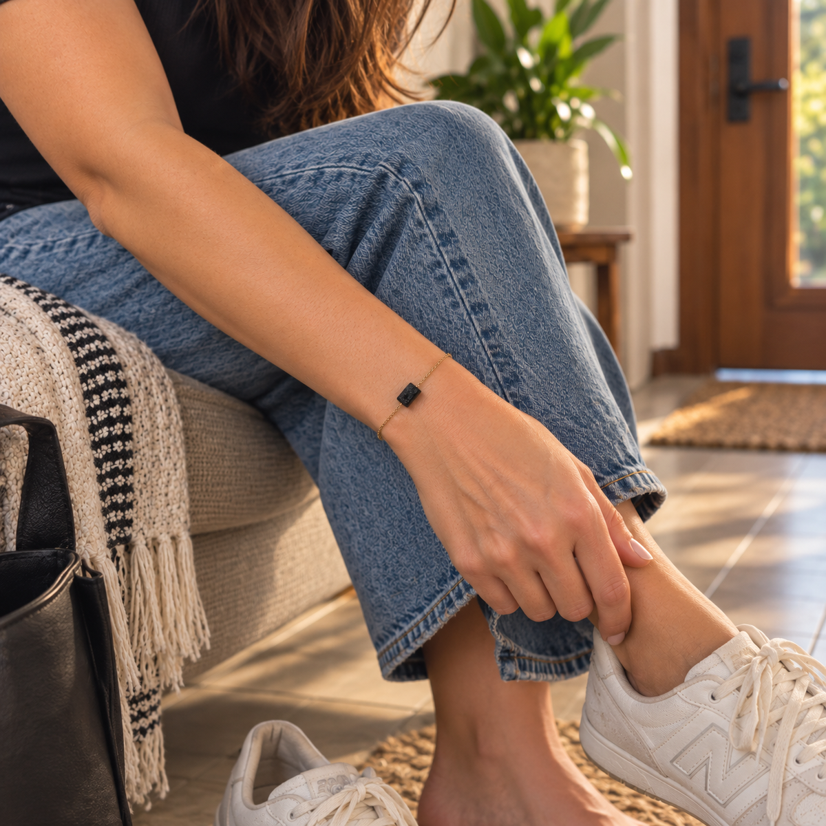 Mujer usando la Pulsera de turmalina negra mientras se quita sus zapatillas new balance