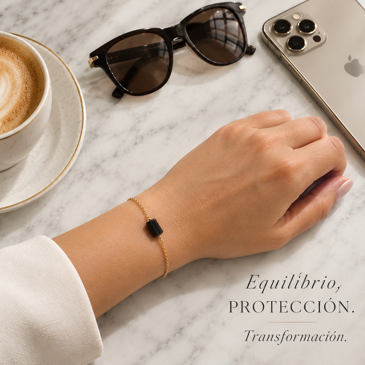 Pulsera de turmalina negra sobre la muñeca junto a un iphone